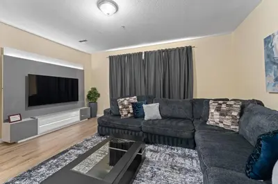 a living room with a couch and a flat screen tv at Luxury 3-Suite Townhome Resort Near Universal in Orlando