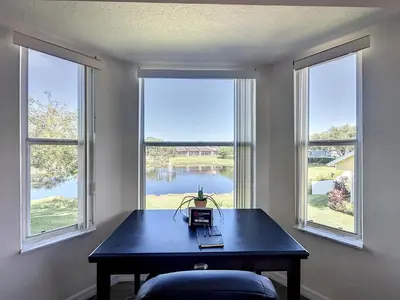 a room with a table and two large windows at Lovely 3 bed Condo Near Disney Quiet Community in Kissimmee