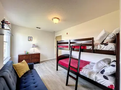 a bedroom with two bunk beds and a couch at Lovely 3 bed Condo Near Disney Quiet Community in Kissimmee
