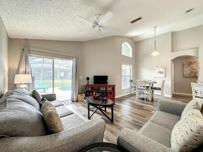 a living room with a couch and a table at Four Bed Three Bath in a gated community with pool in Kissimmee
