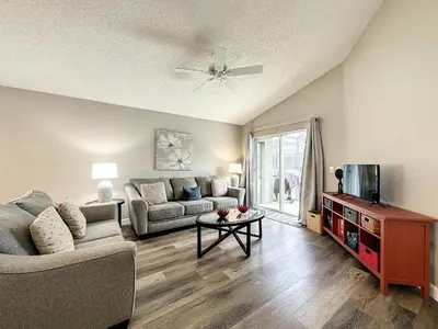 a living room with a couch and a tv at Four Bed Three Bath in a gated community with pool in Kissimmee
