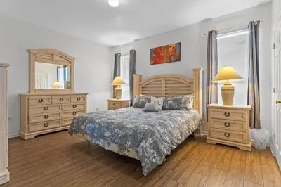 a bedroom with a bed and two dressers and a mirror at Three Bed Private Pool Villa just steps away from in Kissimmee