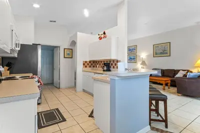 a kitchen and a living room with a couch at Three Bed Private Pool Villa just steps away from in Kissimmee