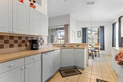 a kitchen with white cabinets and a counter top at Three Bed Private Pool Villa just steps away from in Kissimmee
