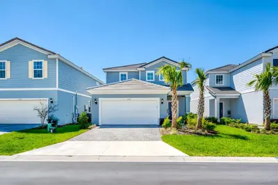 a blue house with palm trees in front of it at DLuxx Summer Vacation Home at Solterra Resort 7391 in Orlando
