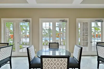 a dining room with a glass table and chairs at DLuxx Summer Vacation Home at Solterra Resort 7391 in Orlando