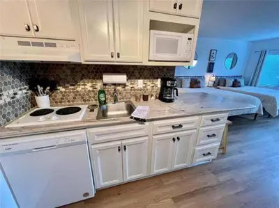 a kitchen with white cabinets and a sink and a bed at Universal-Disney Dream 1211 Studio - The Enclave in Orlando