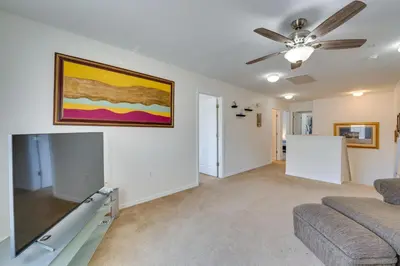 a living room with a couch and a ceiling fan at 22 Mi to Disney Kissimmee Home with Pool and Hot Tub in Kissimmee
