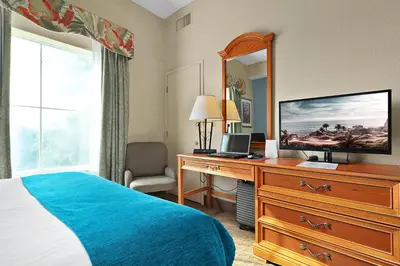 a bedroom with a bed and a dresser with a television at Resort Family condo near Disney Pool view Free parks shuttle in Orlando