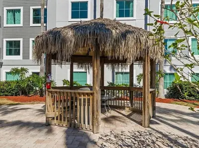 a wooden gazebo with a straw roof at Resort Family condo near Disney Pool view Free parks shuttle in Orlando