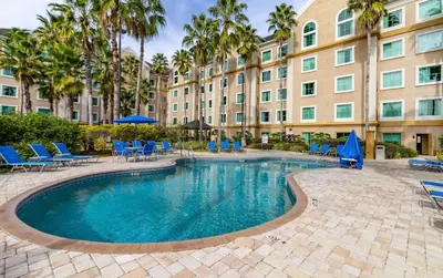 a swimming pool in front of a large building at Resort Family condo near Disney Pool view Free parks shuttle in Orlando