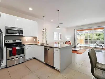 a kitchen with white cabinets and a stove top oven at MEMO Vacation House in Orlando