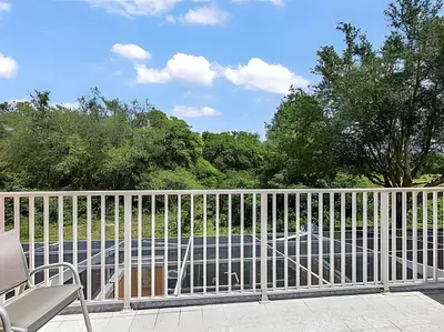 a white fence on a porch with a car at MEMO Vacation House in Orlando