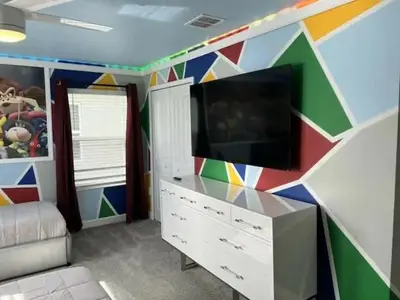 a living room with a tv and a colorful wall at 4323SL-Storey Lake Resort townhouse in Kissimmee