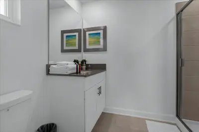 a white bathroom with a sink and a shower at 5 Bedrooms 4 Bathrooms Storey Lake 2533 Rt in Kissimmee