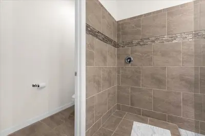 a bathroom with a shower with tiled walls at 6 Bedrooms 5 Bathrooms Solara 1889 Tp in Orlando