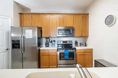 a kitchen with wooden cabinets and stainless steel appliances at Near Pool*Balcony*VistaCay Convention Ctr & Idrive in Orlando