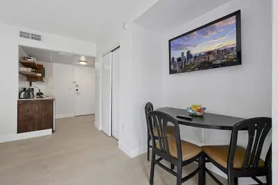 a dining room with a table and chairs and a kitchen at Enclave Refurbished Condo: Just 2mi to Universal! in Orlando