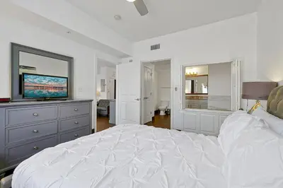 a bedroom with a white bed and a flat screen tv at International Drive Luxury Condo in Orlando