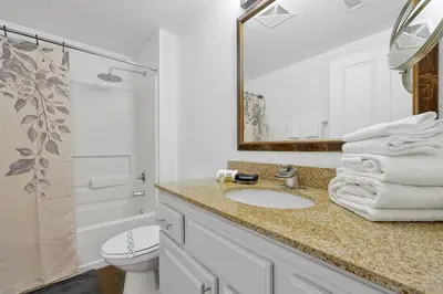 a bathroom with a sink and a toilet and a mirror at International Drive Luxury Condo in Orlando