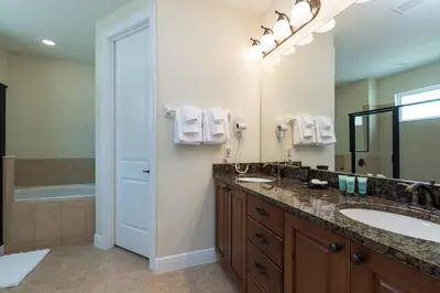 a bathroom with two sinks and a large mirror at Reunion Encore Resort Villa W/ Pool Spa Gameroom in Orlando