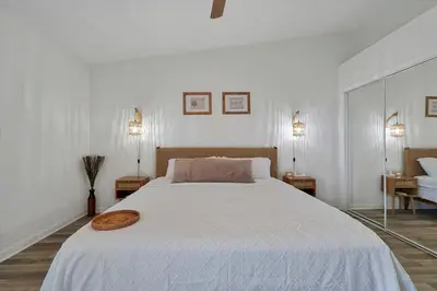 a bedroom with a large white bed and two lamps at Remodeled Retreat: Tranquil Resort Oasis Near Theme Parks in Kissimmee