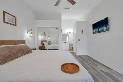 a white bedroom with a large bed with a hat on it at Remodeled Retreat: Tranquil Resort Oasis Near Theme Parks in Kissimmee