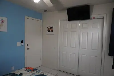a bedroom with a white door and a television on the wall at House of Blues-3 Bedrooms+GameRoom in Orlando