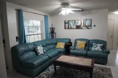 a living room with a couch and a table at House of Blues-3 Bedrooms+GameRoom in Orlando