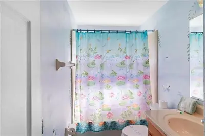 a bathroom with a shower curtain with flowers on it at 1589-IBRHAIM · Charming new 4bd in the heart of Kissimmee 1589 in Orlando