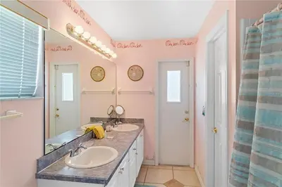 a bathroom with two sinks and a large mirror at 1589-IBRHAIM · Charming new 4bd in the heart of Kissimmee 1589 in Orlando