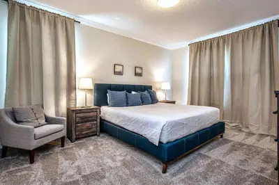 a bedroom with a large bed and a chair at Fancy Family Home 10min-Disney Private Pool STL108 in Kissimmee
