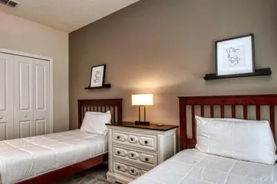 a bedroom with two beds and a table with a lamp at Fancy Family Home 10min-Disney Private Pool STL108 in Kissimmee