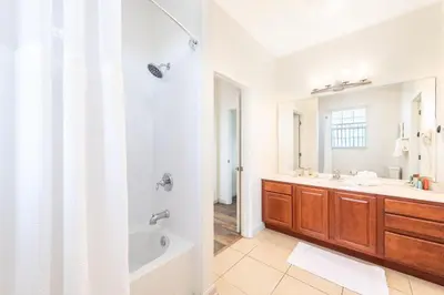 a bathroom with a tub and a sink and a mirror at Pool*Top Floor*Forest Views*Balcony*VistaCay in Orlando