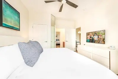 a white bedroom with a bed and a ceiling fan at Pool*Top Floor*Forest Views*Balcony*VistaCay in Orlando
