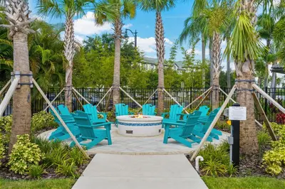 a group of blue chairs on a patio with palm trees at Pool*Top Floor*Forest Views*Balcony*VistaCay in Orlando