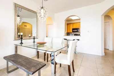 a dining room with a glass table and white chairs at Top Floor*Balcony*VistaCay Convention Ctr & Idrive in Orlando