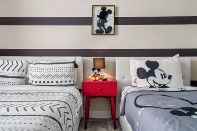 a bedroom with two twin beds and a red nightstand at 4BR Pool Home w Free Waterpark - 9 Min to Disney in Kissimmee