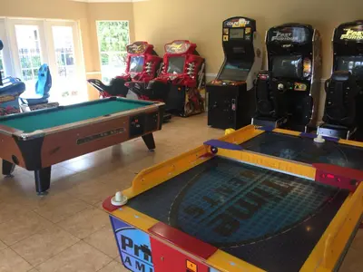 a room with two pool tables and arcade machines at VistaCay Balcony near Pool Convention Ctr iDrive in Orlando
