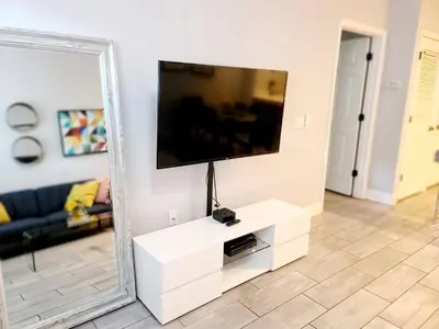 a living room with a television and a mirror at Your home 5 * near Disney in Kissimmee