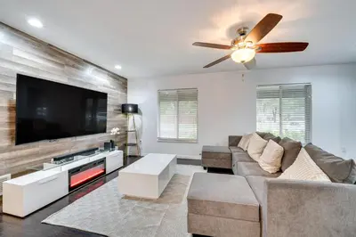 a living room with a couch and a flat screen tv at 7 Mi to Disney World Orlando Home with Private Pool in Orlando
