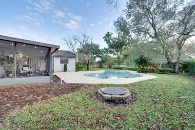 a backyard with a swimming pool and a house at 7 Mi to Disney World Orlando Home with Private Pool in Orlando