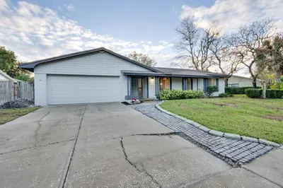 a house with a garage and a driveway at 7 Mi to Disney World Orlando Home with Private Pool in Orlando