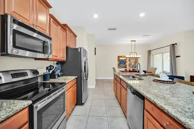 a kitchen with stainless steel appliances and wooden cabinets at Lovely Family Home - 10min to Disney - STL107 in Kissimmee