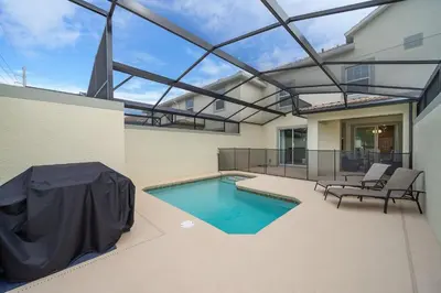 a swimming pool in the backyard of a house at 5013MO TOWNHOUSE 4 BEDROOMS & 3 BATHROOMS + POOL in Kissimmee