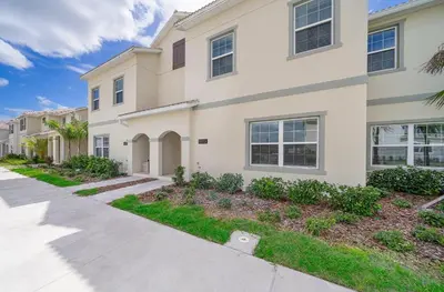 a house with a sidewalk in front of it at 5013MO TOWNHOUSE 4 BEDROOMS & 3 BATHROOMS + POOL in Kissimmee