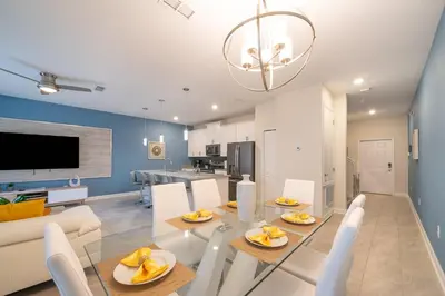 a dining room and kitchen with a glass table and chairs at 5013MO TOWNHOUSE 4 BEDROOMS & 3 BATHROOMS + POOL in Kissimmee