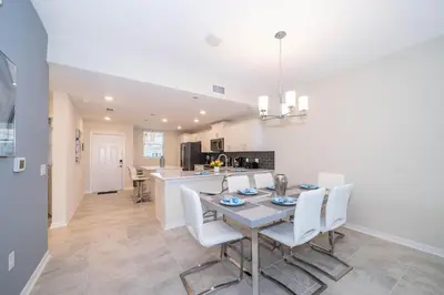 a kitchen and dining room with a table and chairs at 3121-304FR STOREY LAKE, CONDO 2/2 LAKE VIEW in Kissimmee