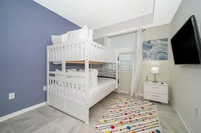 a white bunk bed in a room with a tv at 3121-304FR STOREY LAKE, CONDO 2/2 LAKE VIEW in Kissimmee