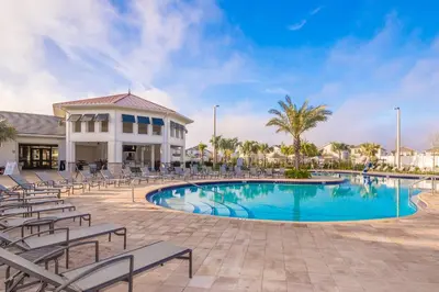 a swimming pool with chairs and a building at 3131-102JJ STOREY LAKE, CONDO 2/2 LAKE VIEW in Kissimmee